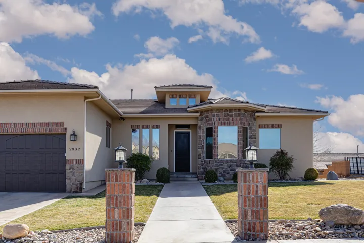 Prairie-style house with stone siding, stucco siding, concrete driveway, and a garage