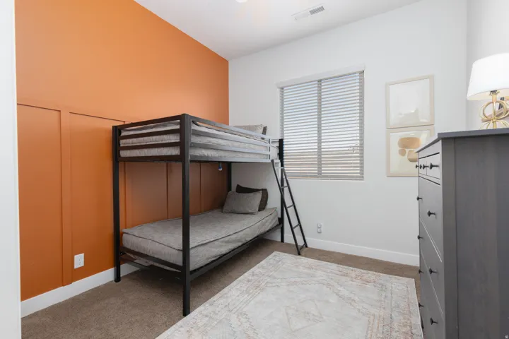Bedroom with light colored carpet and baseboards