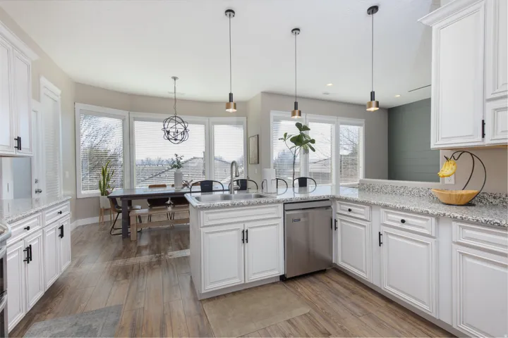 Kitchen featuring white cabinetry, pendant lighting, and dishwasher
