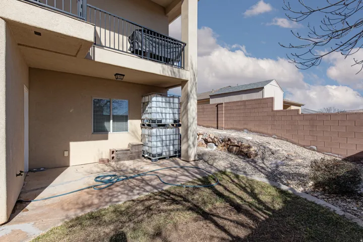 Fenced yard featuring a balcony and a patio area