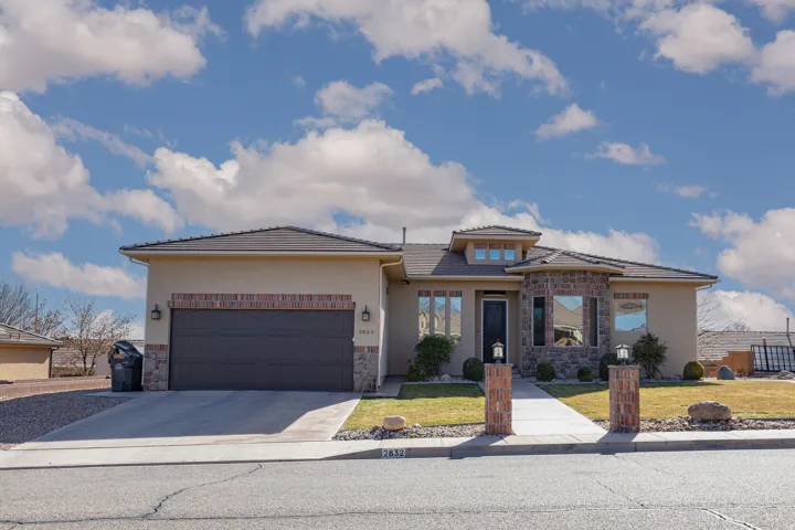 Prairie-style home with stone siding, stucco siding, concrete driveway, and a garage