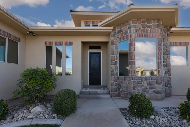 View of exterior entry with stone siding and stucco siding