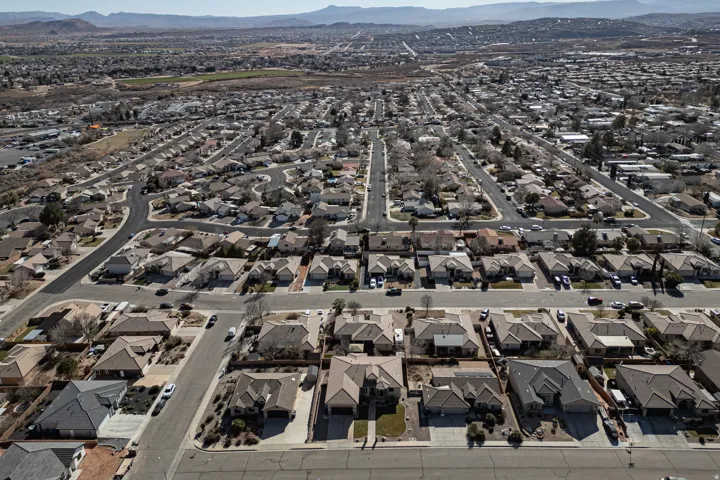 Aerial overview of property's location with a mountain backdrop and nearby suburban area