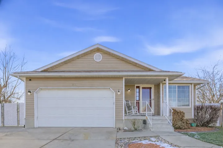 Ranch-style home featuring driveway, covered porch, and a garage