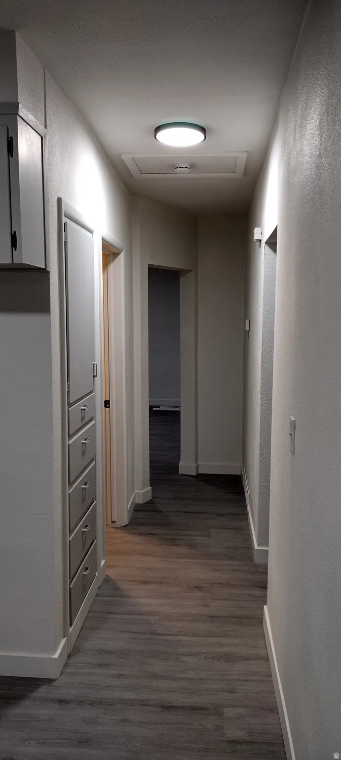 Corridor featuring a textured wall and light flooring