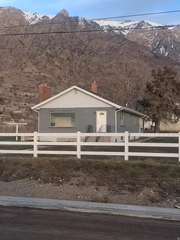 View of front of property with a chimney, a fenced front yard, and a mountain view