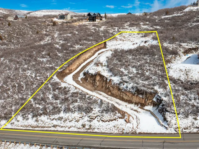 Snowy aerial view with a mountain view and property boundaries highlighted