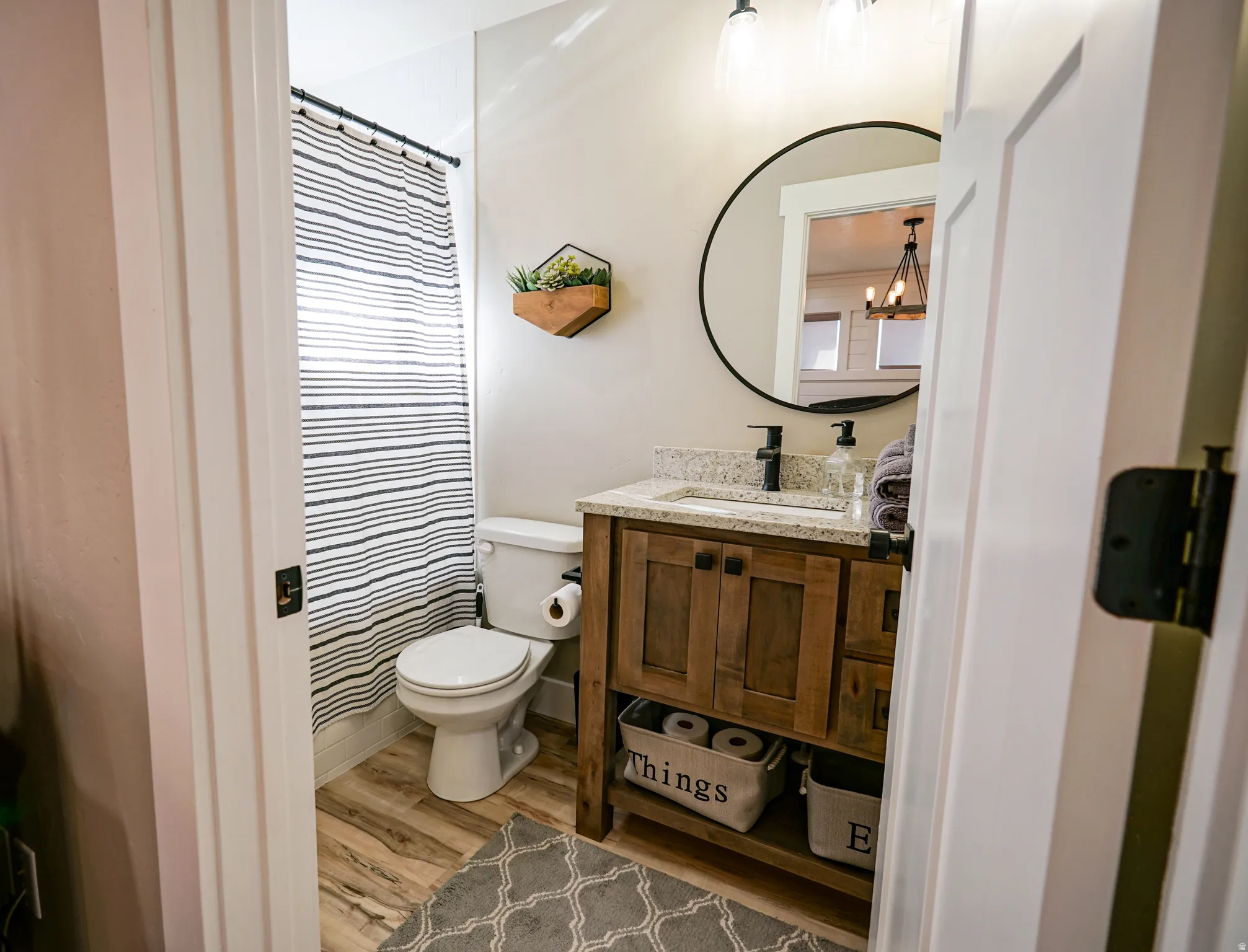 Bathroom featuring vanity, light wood-style flooring, and curtained shower