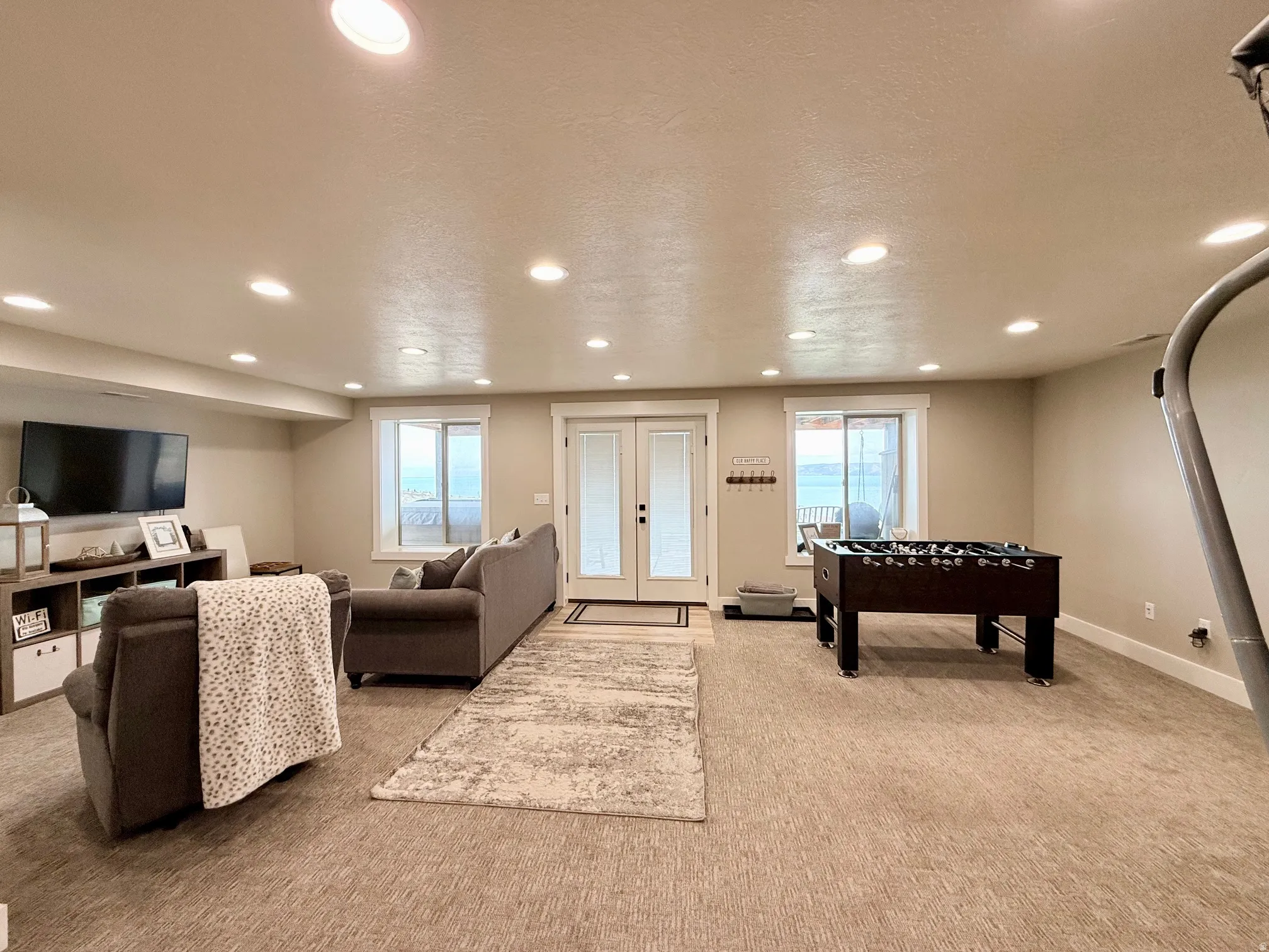 Living area featuring light colored carpet, a textured ceiling, and recessed lighting