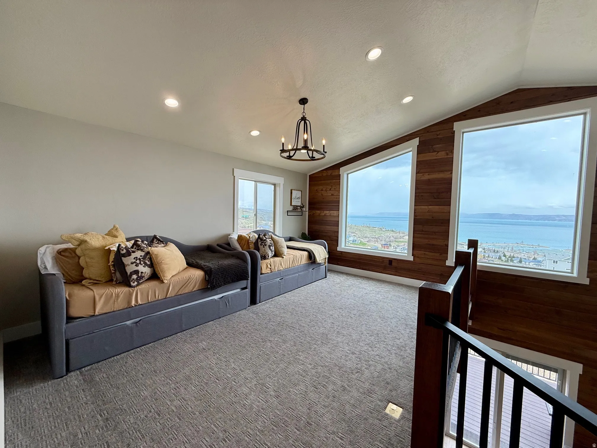 Carpeted home theater room with wood walls and a chandelier