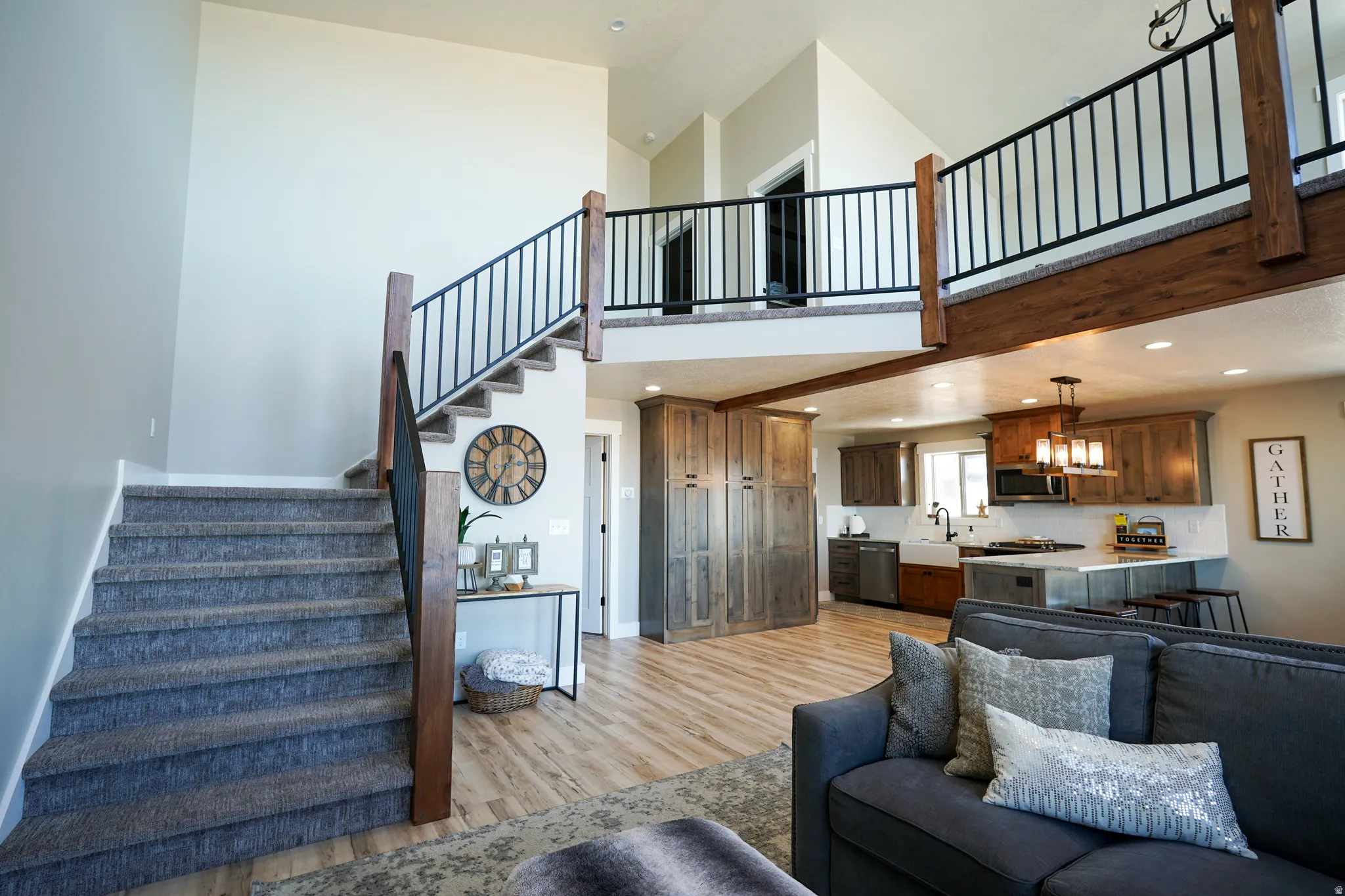 Living room with light wood-style floors, recessed lighting, and a high ceiling