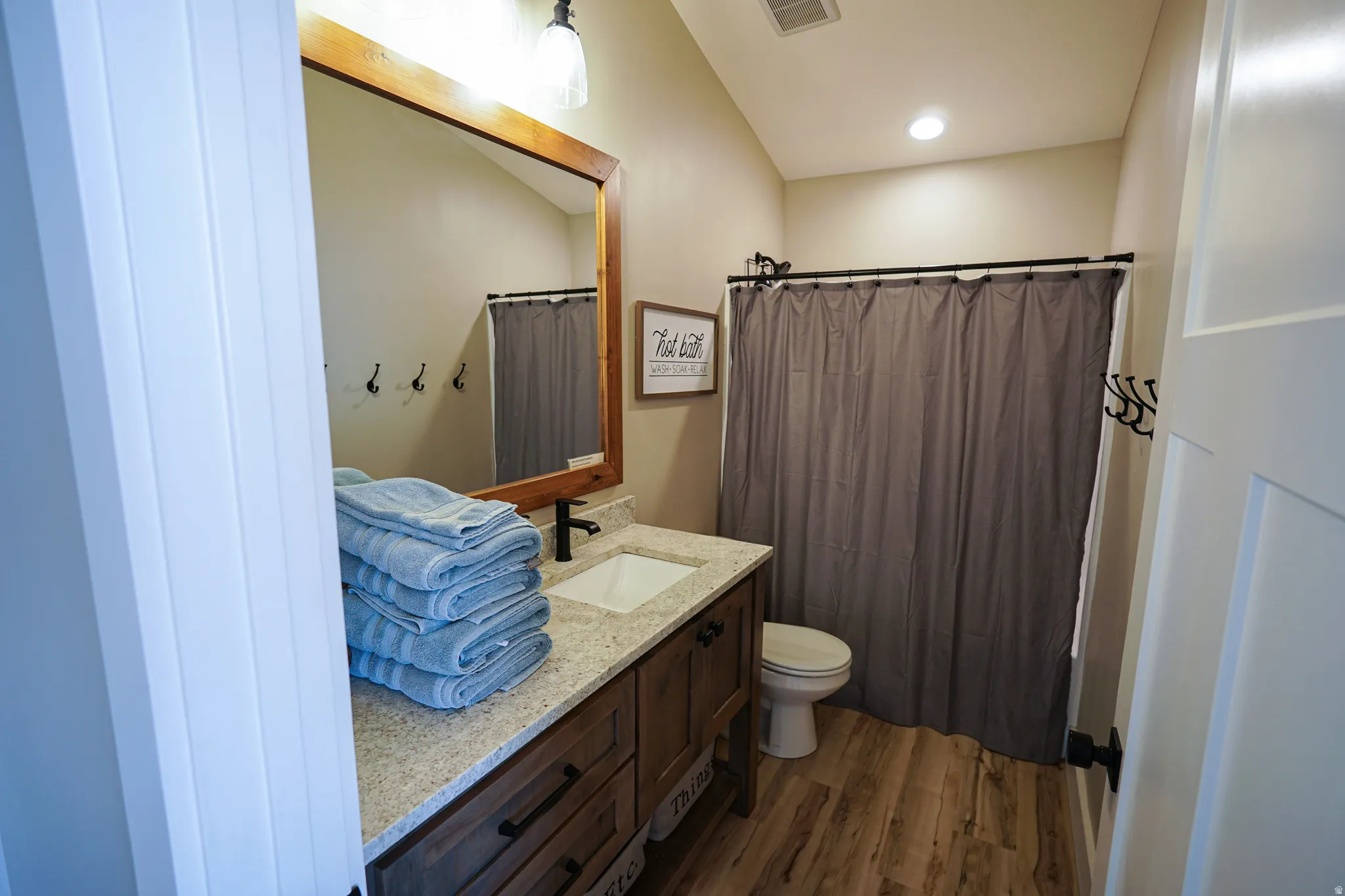 Bathroom with vanity, dark wood finished floors, and recessed lighting