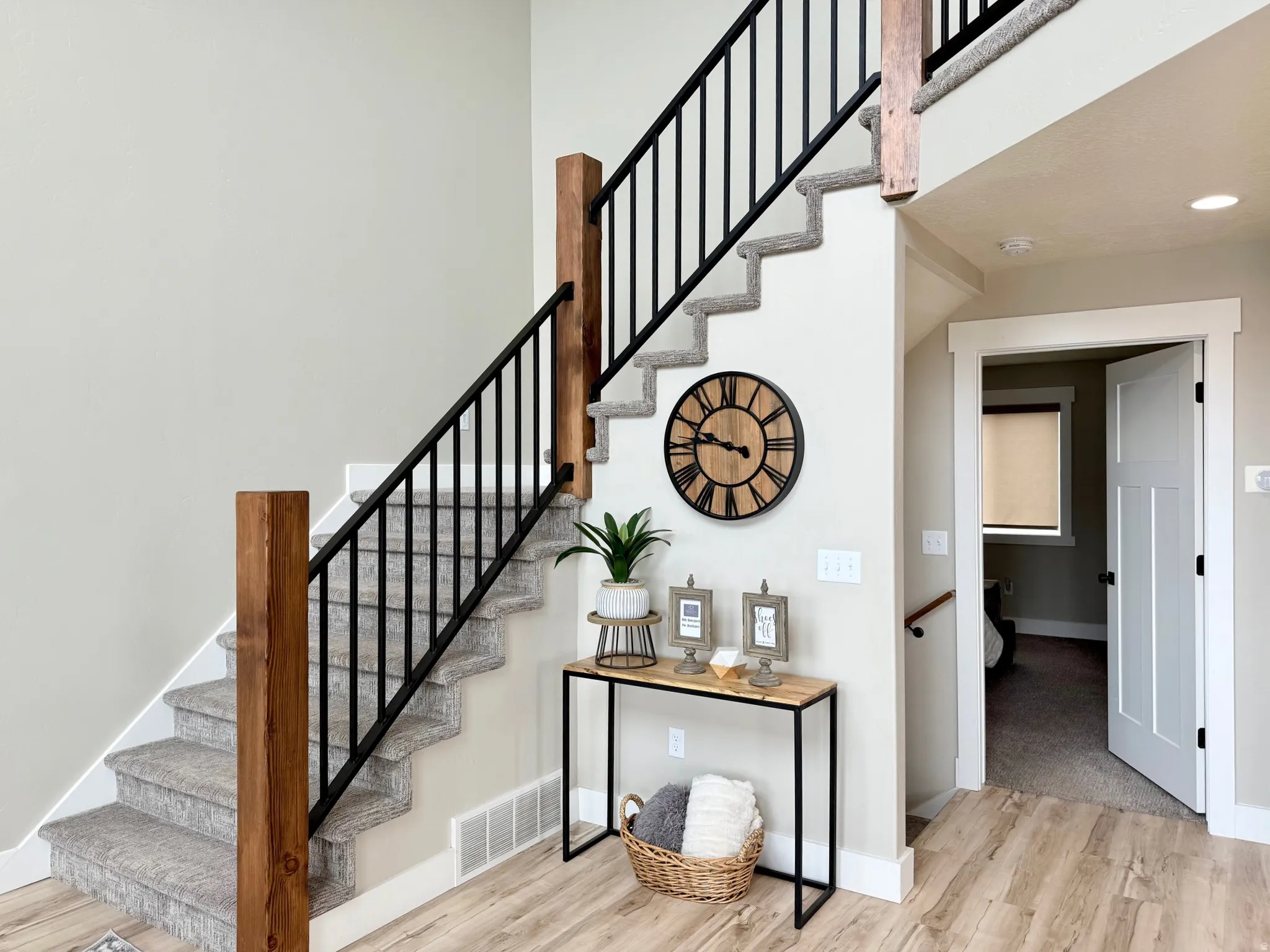Stairs with wood finished floors and a high ceiling