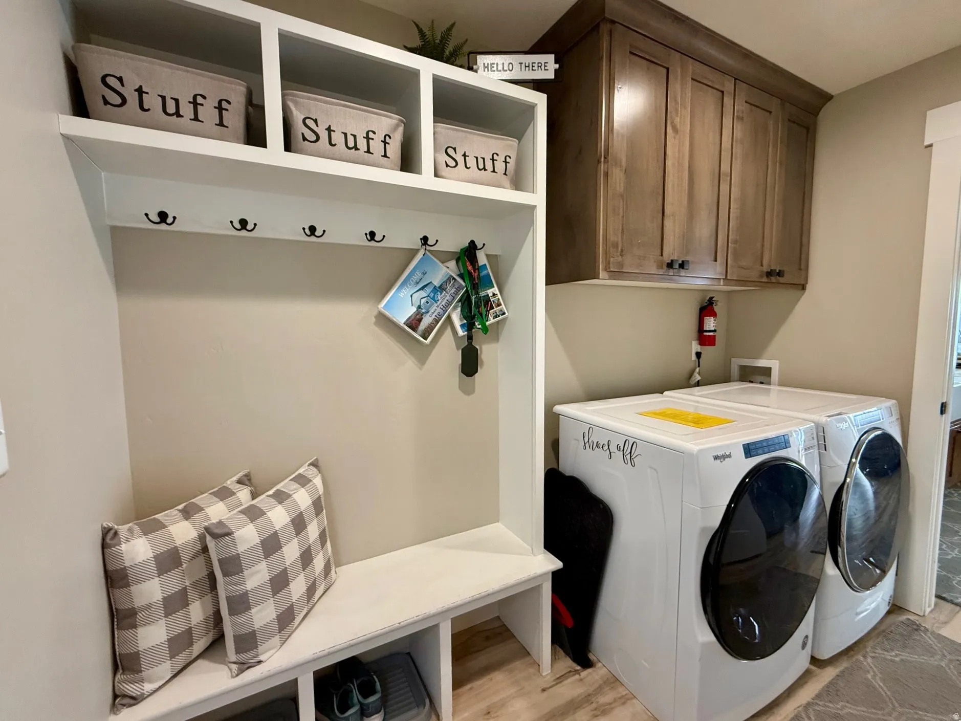 Laundry room featuring light wood-style floors, washing machine and clothes dryer, and cabinet space