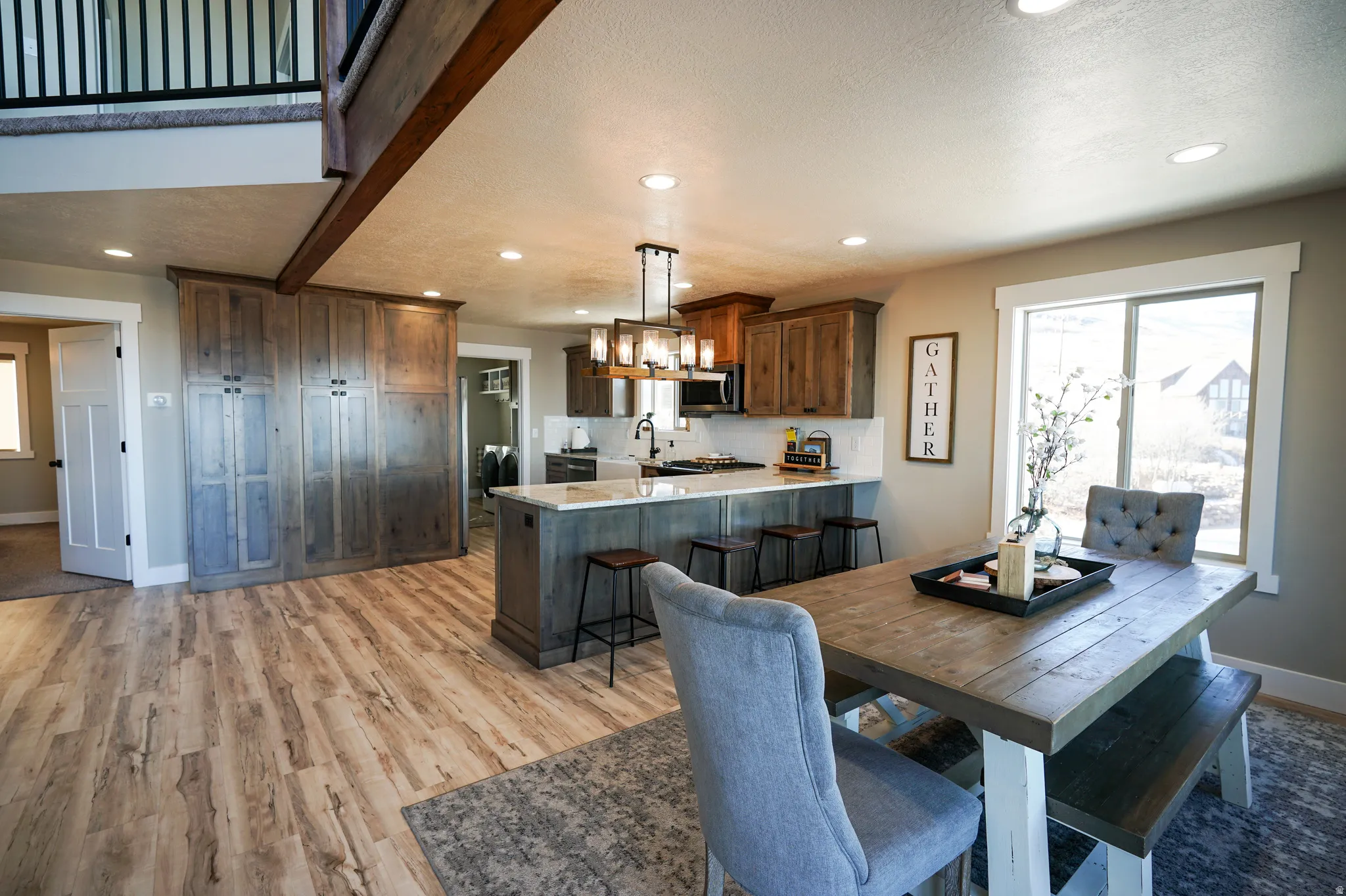 Dining room featuring light wood-type flooring, recessed lighting, and a textured ceiling