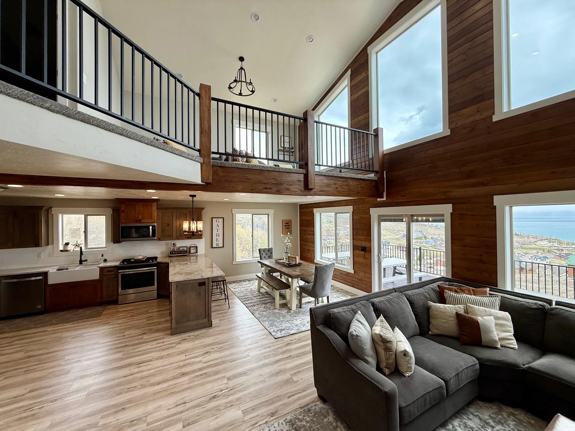 Living area featuring wooden walls, light wood-type flooring, a high ceiling, and recessed lighting