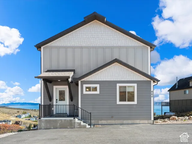 Multi-level exterior with shingle and vertical panel siding, dark trim, and a covered entry