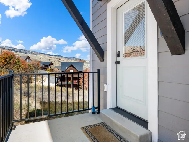 Front entry featuring a white door with a window, grey siding, and a concrete stoop