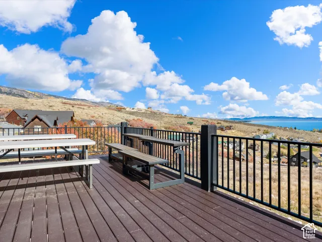 Expansive deck featuring composite decking, black metal railings, and a prominent water body in the distance