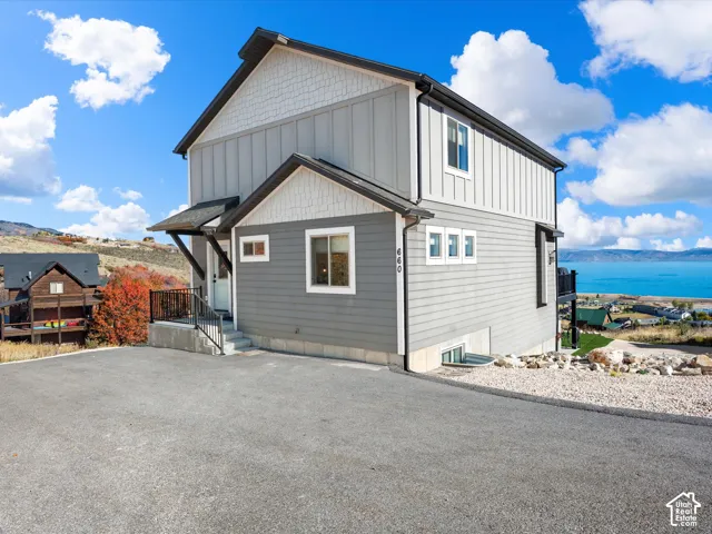 Contemporary exterior with horizontal and vertical siding, a paved driveway, and a prominent balcony