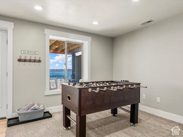 Recessed lighting, light gray wall paint, white trim, and a window with a water backdrop