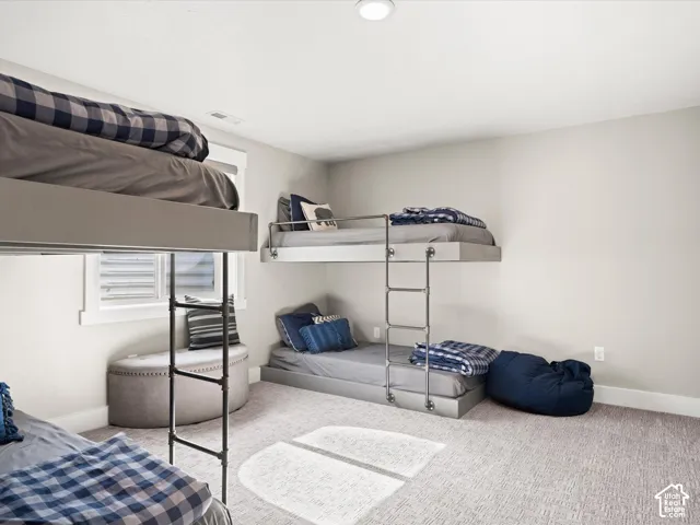 Recessed lighting, light gray walls, white window trim, and light-colored carpeting