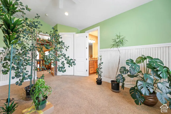 Living area with wainscoting, carpet floors, vaulted ceiling, and recessed lighting