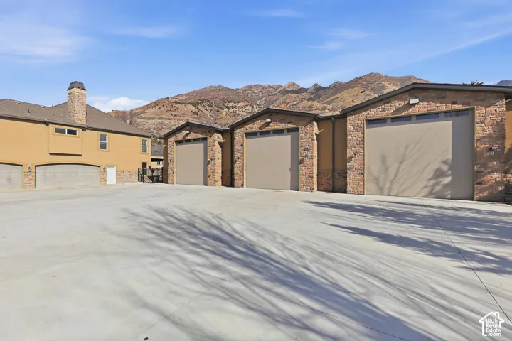Prairie-style house with driveway, stucco siding, and stone siding