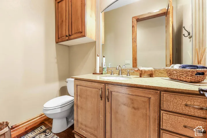 Half bath featuring vanity and dark wood-style flooring