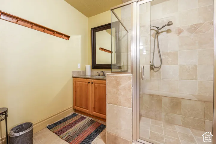 Bathroom featuring a stall shower, vanity, and light tile patterned floors
