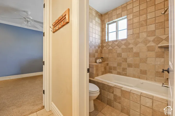 Full bathroom featuring tiled shower / bath, a ceiling fan, tile patterned floors, and carpet