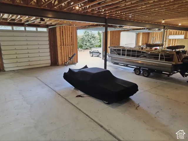 Large garage space with exposed wood ceiling beams and structural steel supports