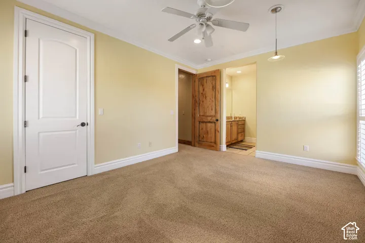 Unfurnished bedroom with carpet flooring, ornamental molding, a ceiling fan, connected bathroom, and recessed lighting