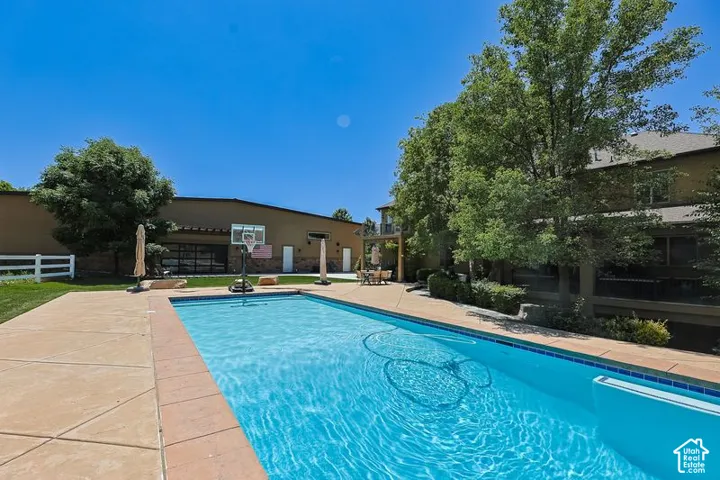Sparkling resort-style swimming pool with crystal-clear water and sun deck featuring stamped concrete decking