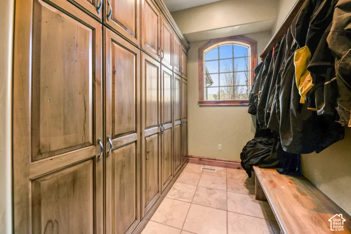 Mudroom with light tile patterned floors and baseboards