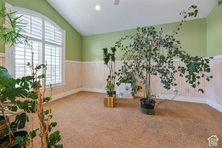 Unfurnished room featuring wainscoting, lofted ceiling, carpet floors, and recessed lighting