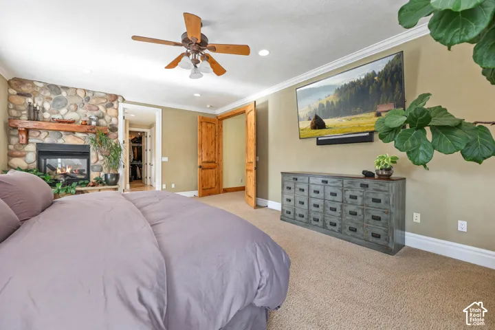 Bedroom with crown molding, a fireplace, ceiling fan, carpet, and recessed lighting