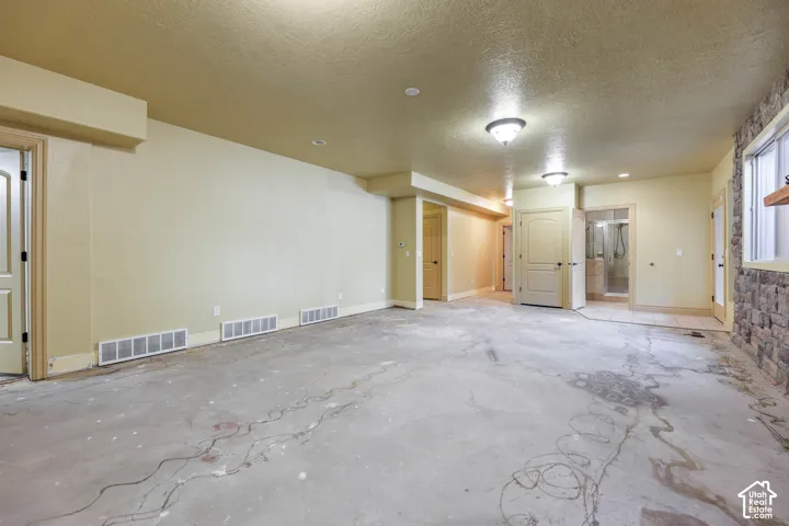 Unfurnished room featuring a textured ceiling and concrete flooring