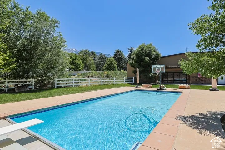 Resort-style swimming pool featuring crystal-clear water, brick decking, and integrated spa jets