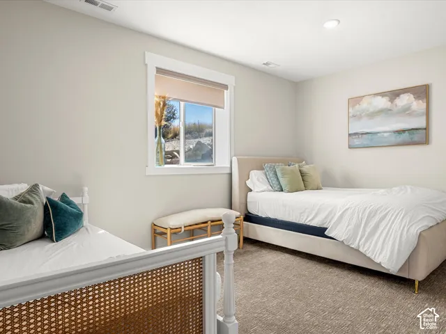 Neutral wall color, recessed lighting, window with roller shade, carpeted flooring