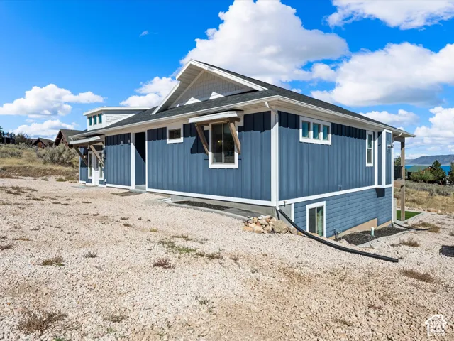 Blue vertical siding, white trim accents, and a tiered roofline with exposed rafter tails