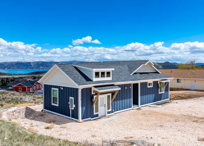 View of front of property with a mountain view, roof with shingles, and board and batten siding