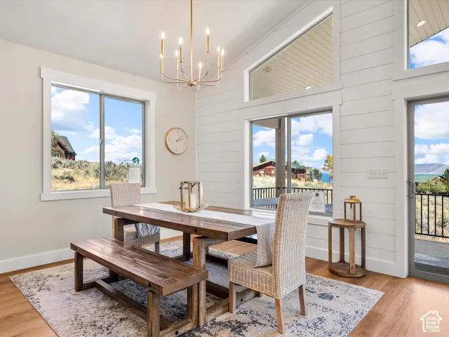Vaulted ceiling with an angular transom window, wood-finish flooring, and white shiplap accent wall