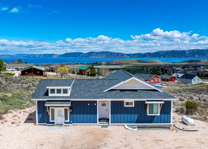 View of front of house featuring a mountain view, a shingled roof, covered porch, and board and batten siding