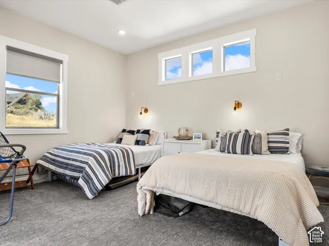 Recessed lighting, wall-mounted sconces, and multiple windows provide ample illumination
