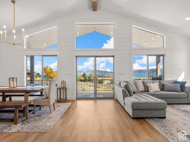 Vaulted ceiling featuring shiplap walls, wood-finish flooring, and multiple transom windows
