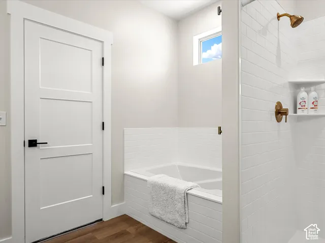 White subway tile shower surround with integrated shelving and brass-finish fixtures
