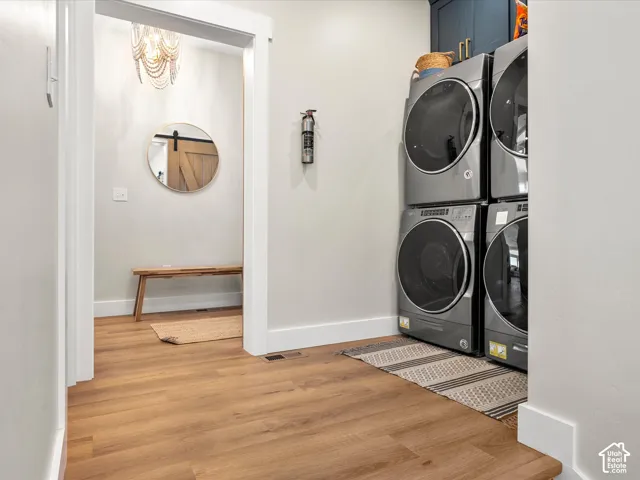 Wood-finish flooring throughout, bright white trim, and a stacked washer and dryer