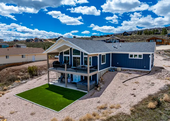 Back of house featuring a shingled roof, a residential view, a patio area, and a wooden deck