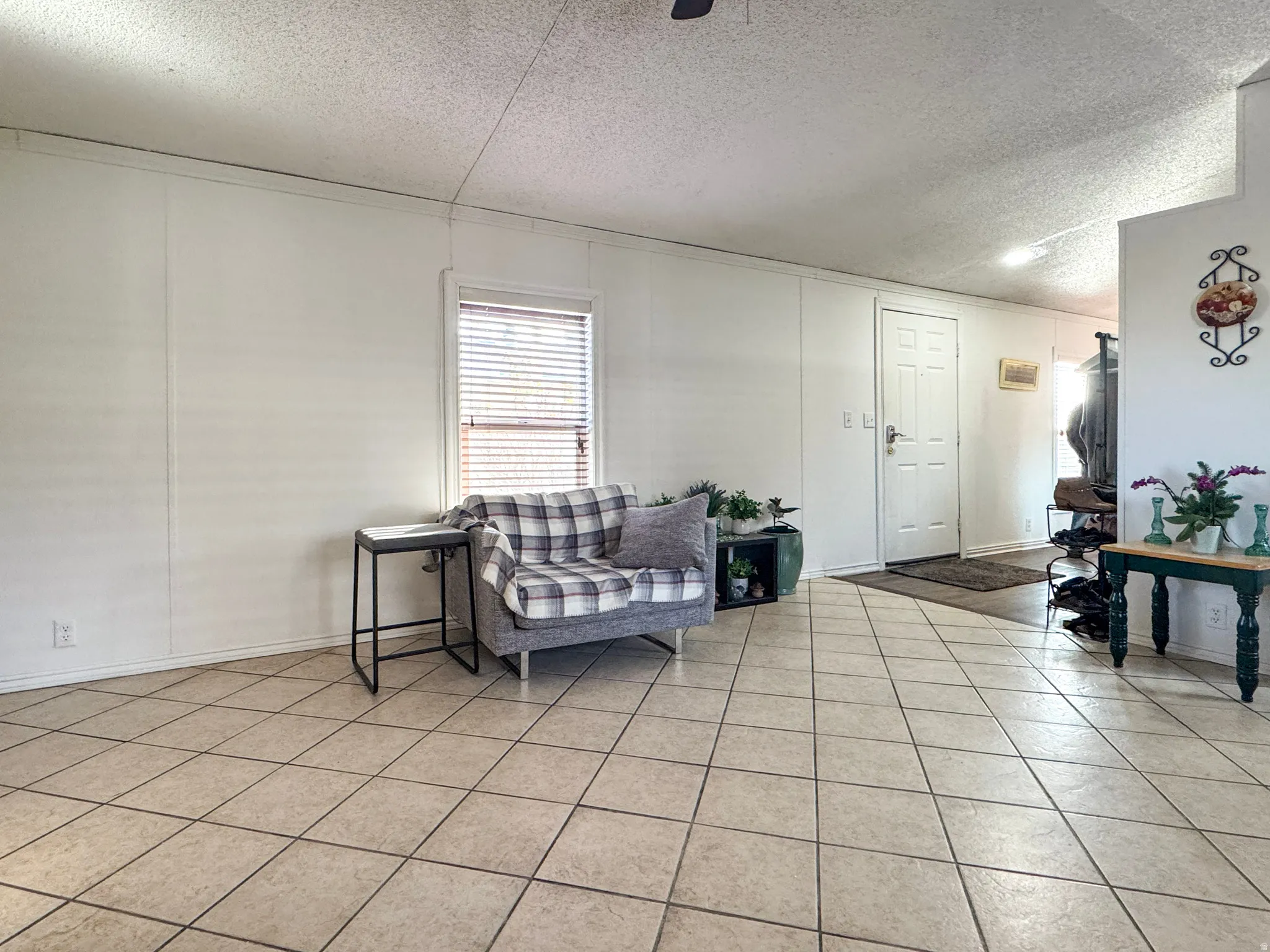 Living room featuring a textured ceiling and light tile patterned floors